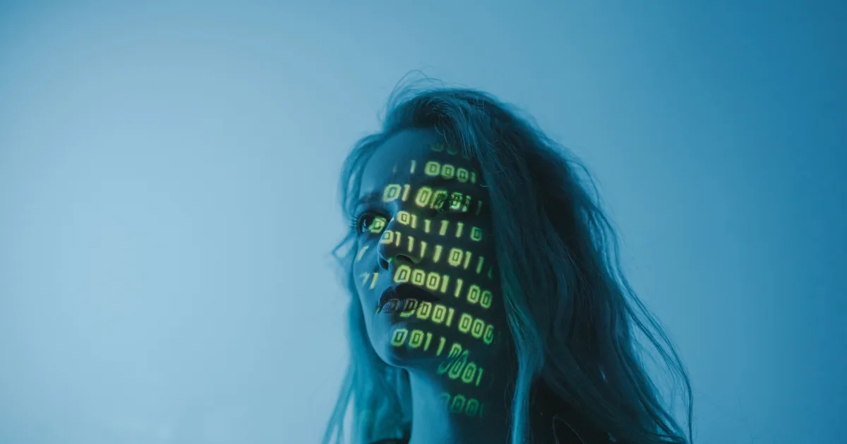 Woman with binary code projected across her face, symbolizing digital and AI-driven interaction